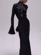 Black polka dot bell-sleeve dress with high neck and fitted midi silhouette