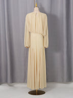 Cream pleated maxi dress with long sleeves, round neckline, and gathered waist