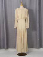 Cream pleated maxi dress with long sleeves and softly draped shoulders