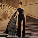 Black one-shoulder evening gown with beaded embellishment, flowing tulle drape and slit