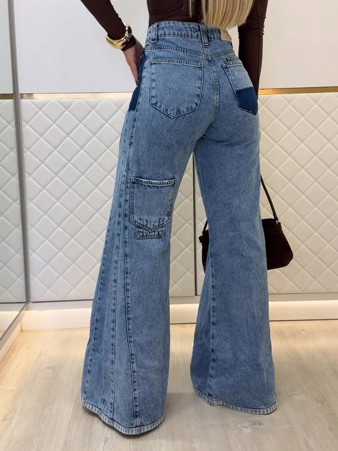Light blue high-waist flared jeans, back view with patch pockets and stitched seams
