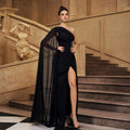 Black one-shoulder evening gown with beaded bodice, draped tulle overlay, thigh slit