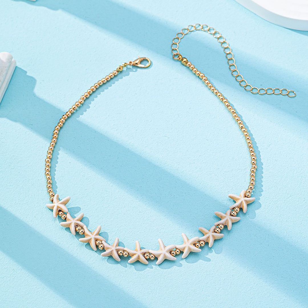 Gold-tone beaded necklace with starfish charms and small round bead accents