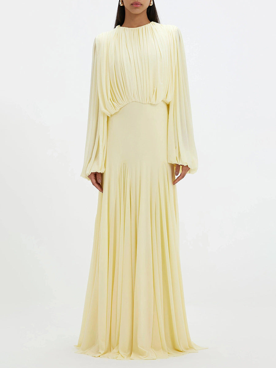 Pale yellow pleated maxi dress with long sleeves and gathered waistline
