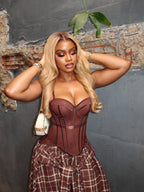 Brown corset top with structured cups and plaid asymmetrical skirt with draped overlay