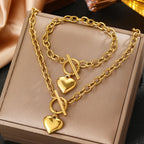 Gold-tone heart pendant bracelet and necklace set with interlinked chain and toggle bar