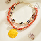 Orange rope necklace with conch shells, starfish, and a yellow scallop shell charm