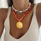 Orange conch rope necklace with starfish charms and yellow scallop shell pendant on neckline