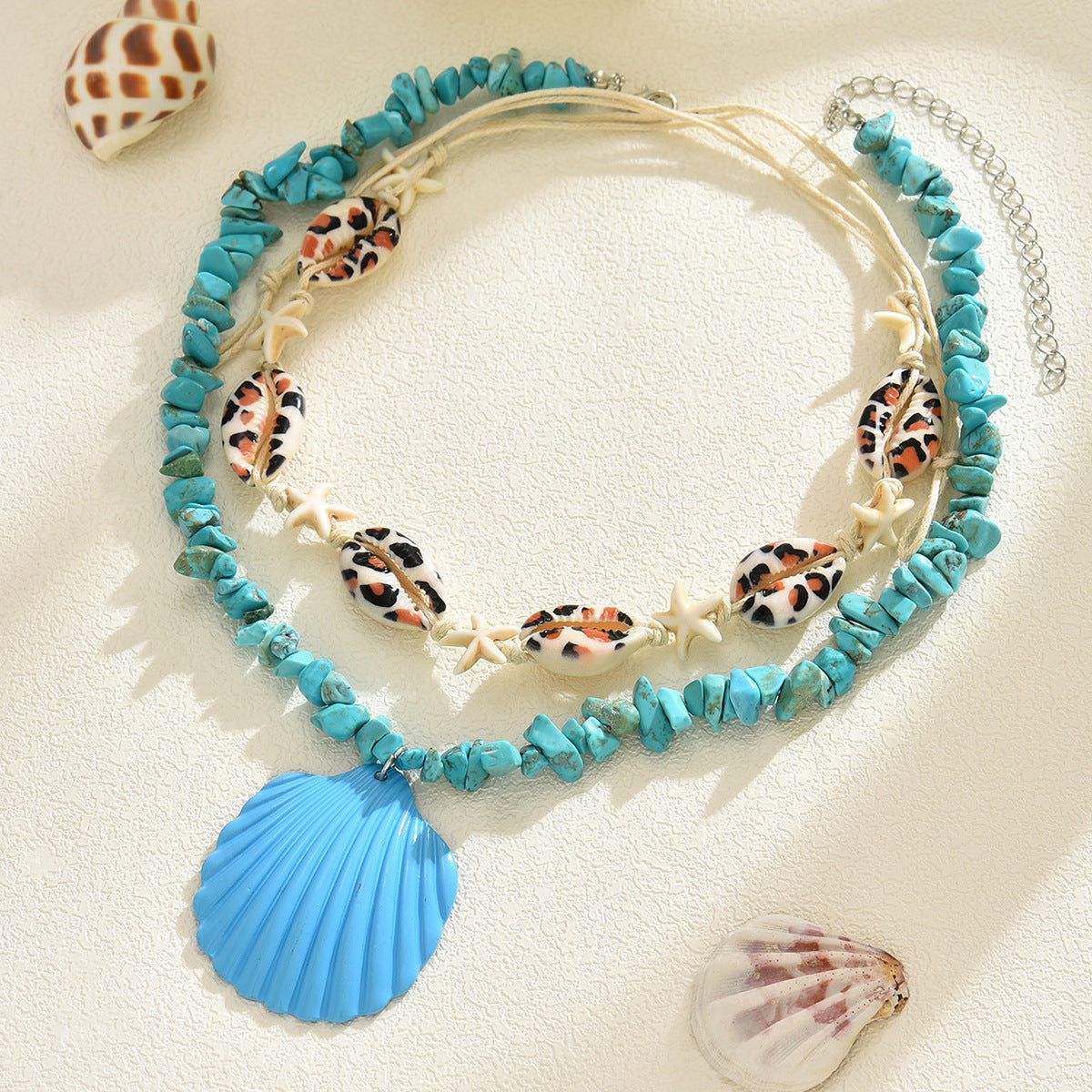 Turquoise conch rope necklace on beige cord with starfish charms and blue scallop shell pendant