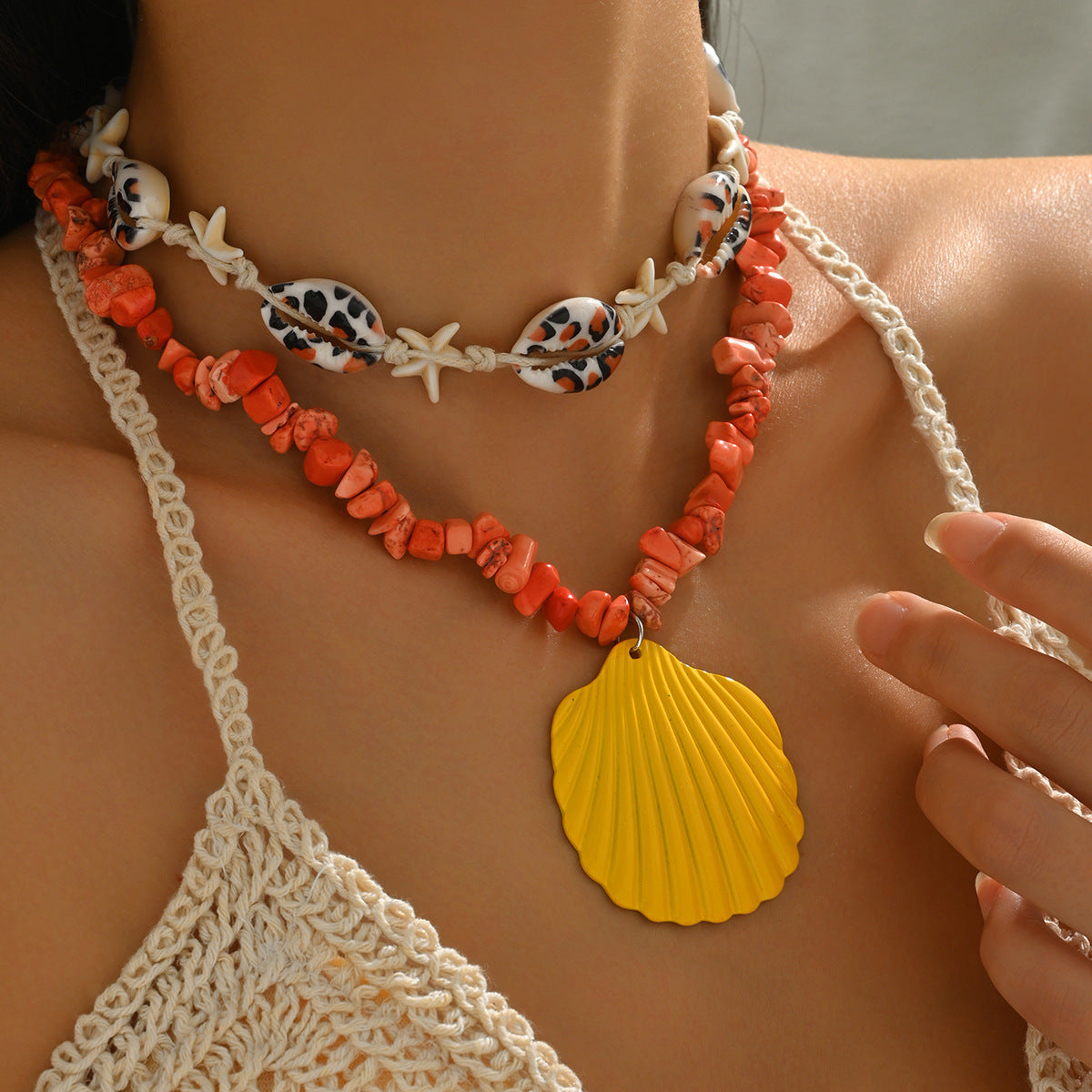 Orange conch rope necklace with starfish charms and yellow scallop shell pendant