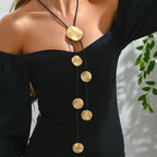 Gold disc tassel necklace with black cord and multiple round metal pendants