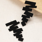 Geometric stud earrings in black featuring jagged zigzag shapes and an earring post