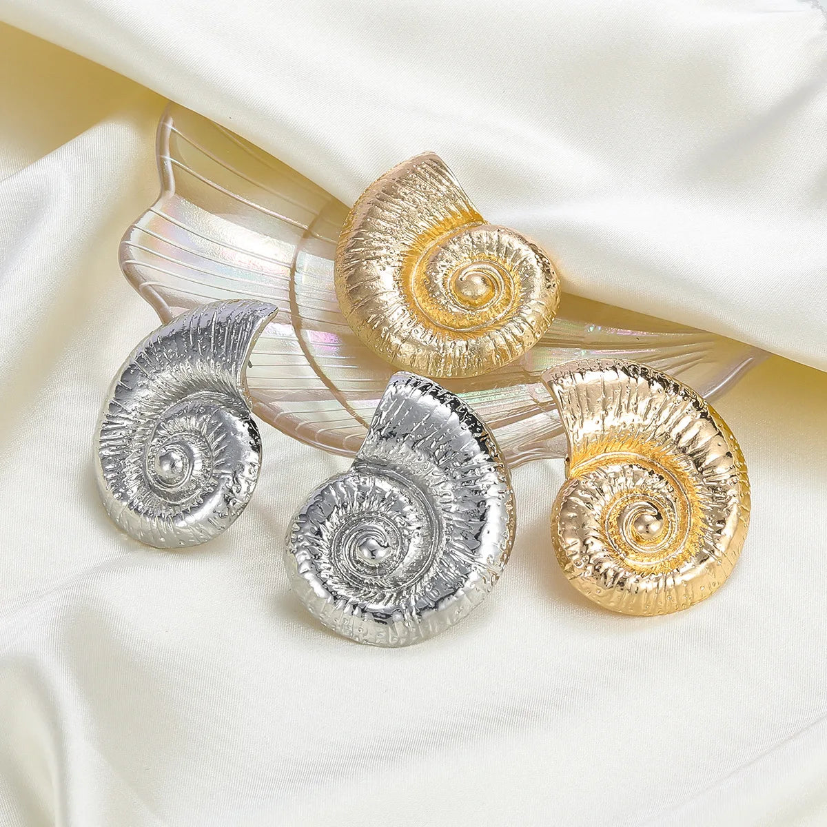 Conch shell stud earrings in silver and gold tones, round textured spiral design