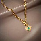 Gold-tone chain necklace with green square stone heart pendant and round toggle clasp