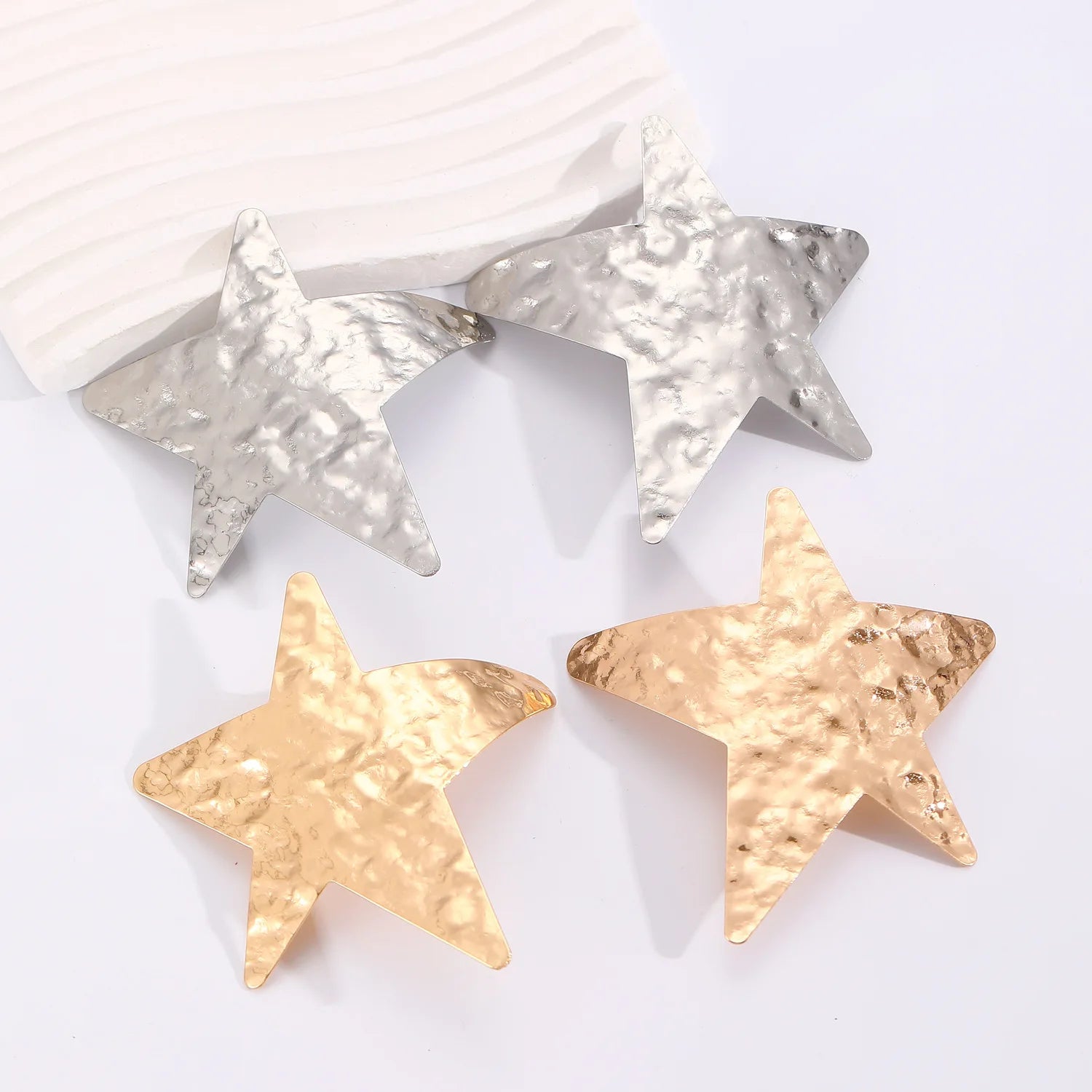 Star-shaped wrinkled drop earrings in silver and gold, dangling style