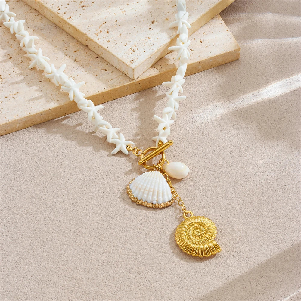 White shell-link necklace with gold-tone conch pendant and hanging white shell drops