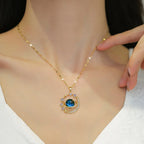 Gold-tone zircon planet pendant necklace with blue circular gemstone and star accents