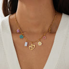 Gold enamel pendant necklace with heart, white block, and colorful flower charms