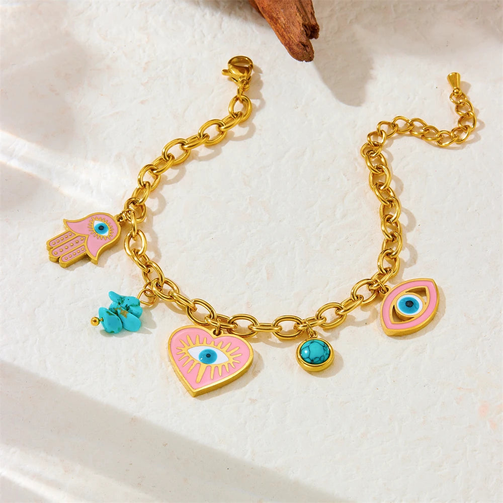 Gold-tone charm bracelet with evil eye heart, hamsa hand, and turquoise bead accents