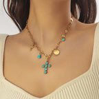 Gold-tone cross pendant necklace with turquoise bead drops
