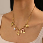 Gold-tone multi-pendant necklace with dolphin, starfish, pearl and seashell charms