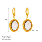 Gold hoop earrings with oval white cameo pendant in gold filigree frame