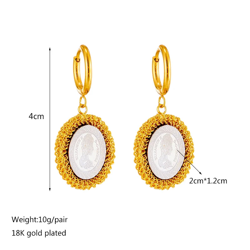 Gold hoop earrings with oval white cameo pendant in gold filigree frame