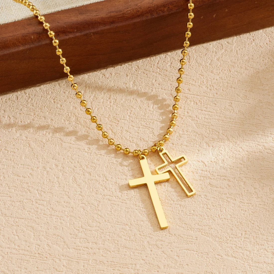 Gold cross pendant necklace with double cross charm on a beaded chain