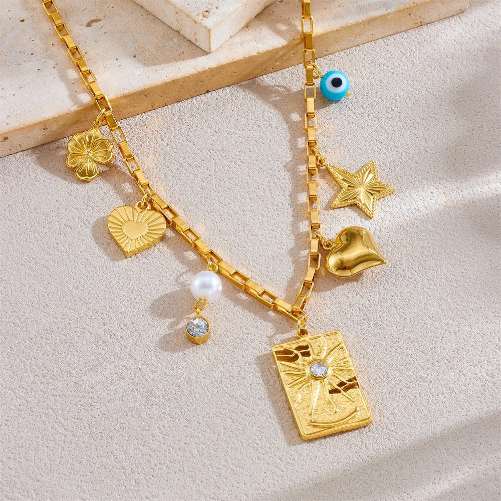 Gold-tone charm necklace with evil-eye bead, star, heart, square pendant, pearl and zircon