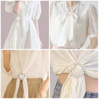Scarf tie brooch clip with pearl accents fastening a white blouse neck bow