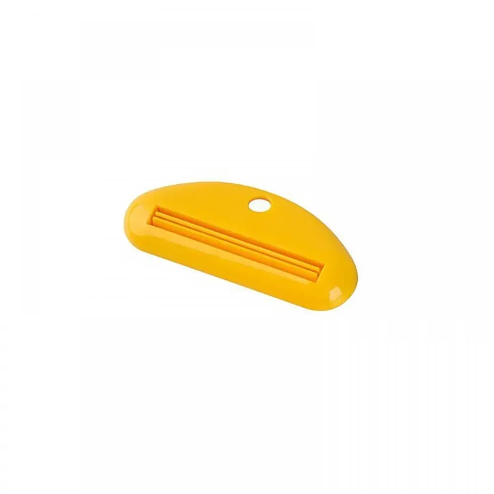 Yellow toothpaste tube squeezer dispenser with slotted metal insert and hanging hole