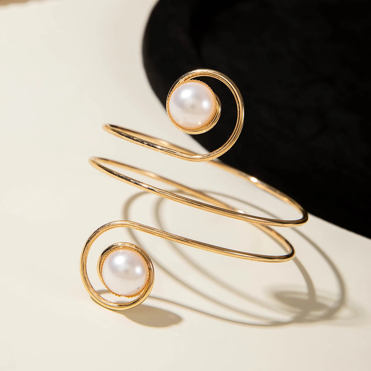 Gold-tone upper arm bracelet with spiral wire and round pearl stone accent