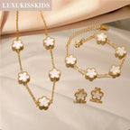 Gold-tone clover jewelry set with white enamel necklace, bracelet, and matching stud earrings