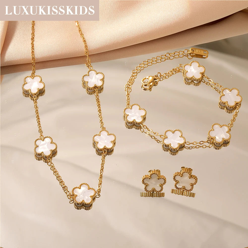 Gold-tone clover jewelry set with white enamel necklace, bracelet, and matching stud earrings