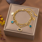 Gold-tone evil-eye double bangle bracelet with blue teardrop charms