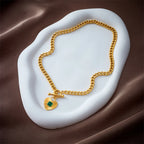 Gold-tone heart pendant necklace with green square stone set in a heart charm
