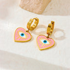 Gold-tone heart dangle earrings with pink enamel evil eye motifs