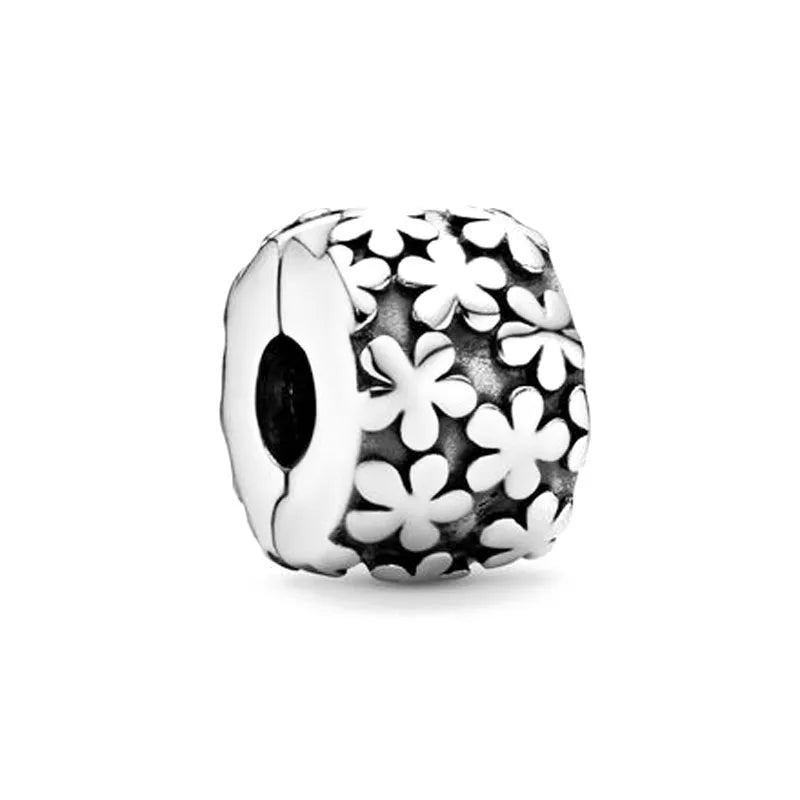 Sterling silver charm bead with floral cutout pattern on the round face
