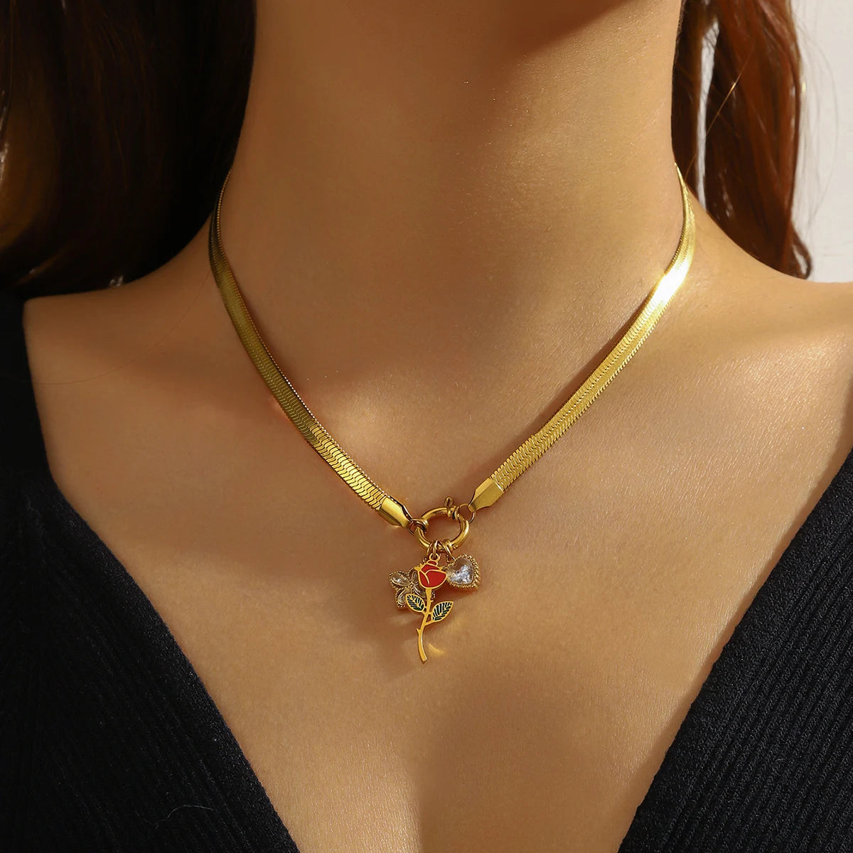 Gold-tone snake chain necklace with rose flower pendant and red heart charm