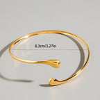 Gold-tone spiral upper arm bracelet with curved open bangle silhouette