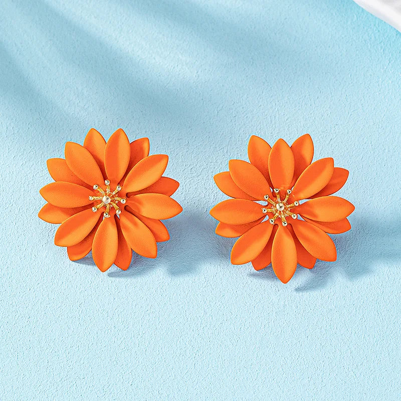 Orange enamel flower stud earrings with gold-tone center and small crystal details.