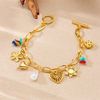 Gold-tone charm bracelet with heart, flower, pearl and shell charms, turquoise bead accents