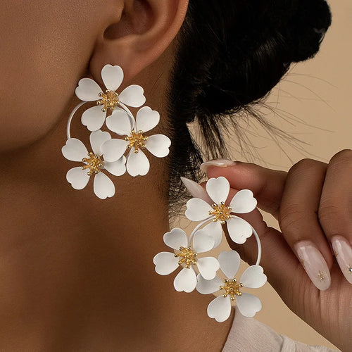 White camellia-style flower dangle earrings with gold-tone star centers and hoop links