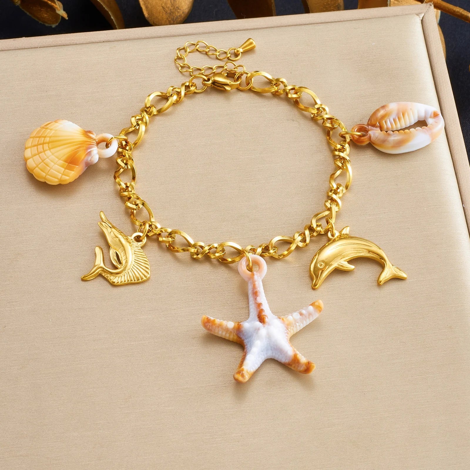 Gold-tone enamel ocean charm bracelet with starfish, dolphins and shell conch charms