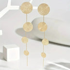 Gold-tone disc dangle earrings, four woven circles with thin chain tassel