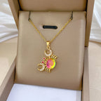 Gold-tone crab pendant necklace with pink round gemstone, red dots, and clear stones.