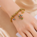 Gold-tone beaded charm bracelet with blue eye and palm hand charm