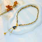 Gold-tone heart pendant necklace with black charm and pearl and gold ball dangles