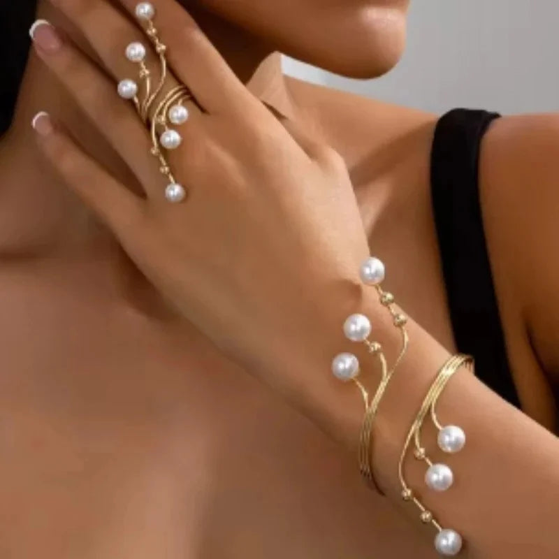 Gold-tone pearl beaded bracelet with curved links and white pearl drops