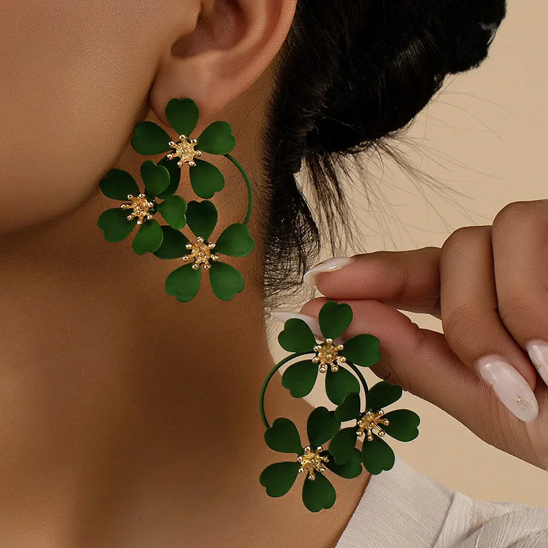 Flower dangle earrings with dark green five-petal flowers on gold-tone hoops